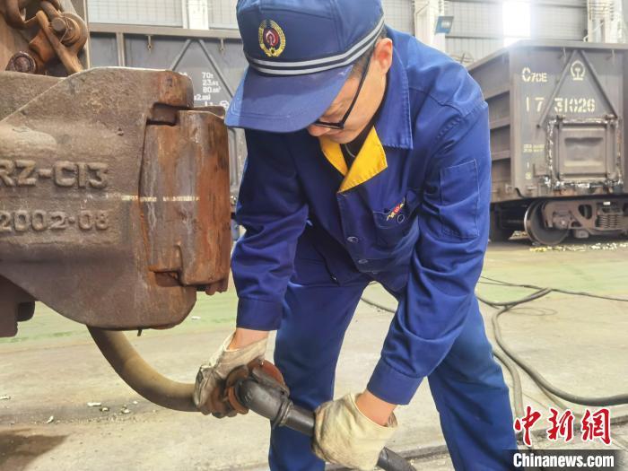 張光啟正在連接風(fēng)管，給鐵路貨車(chē)車(chē)輛送風(fēng) 潘敏 攝